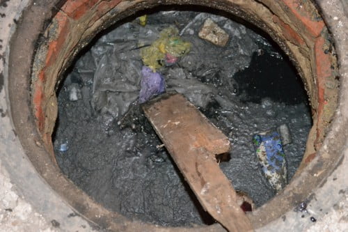 Фото: засоренный канализационный колодец