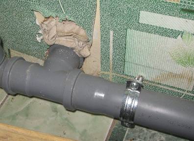 Фото: закрепляем канализационный трубопровод к стене